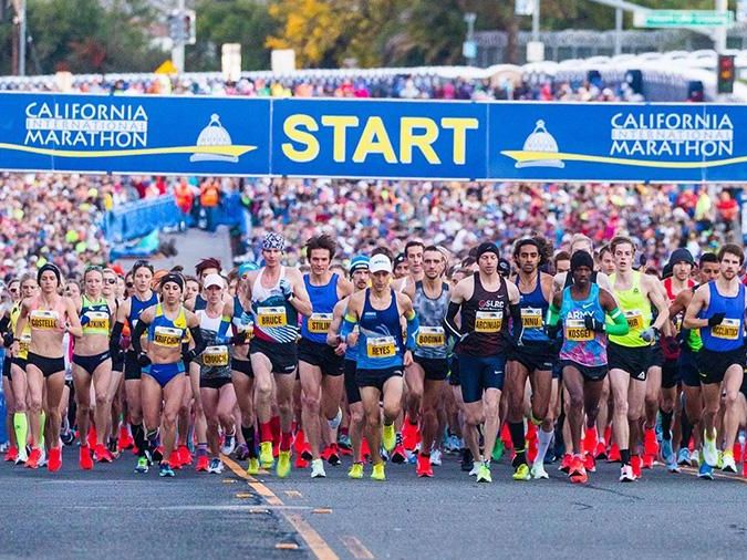 Runners lined up at the start of an outdoor road race, the kind of event served by a mobile water station