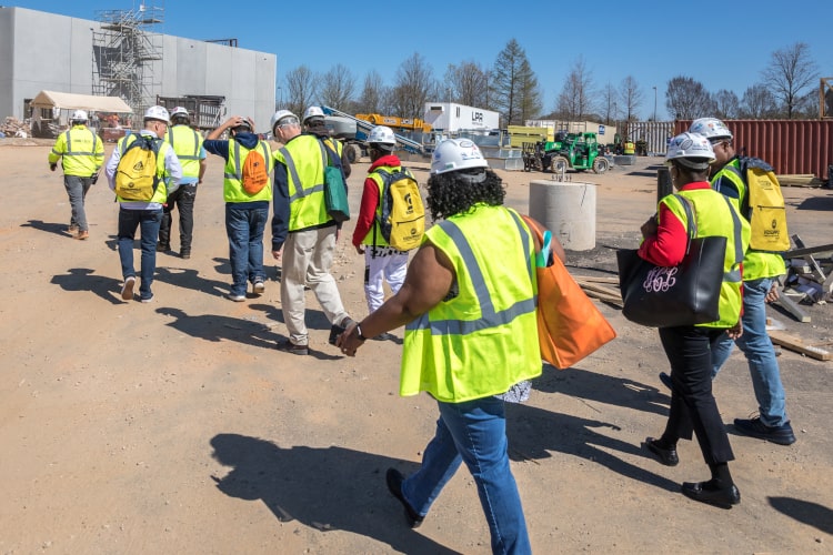Glendale construction crew in high-visibility vests on an outdoor job site with a mobile water station nearby