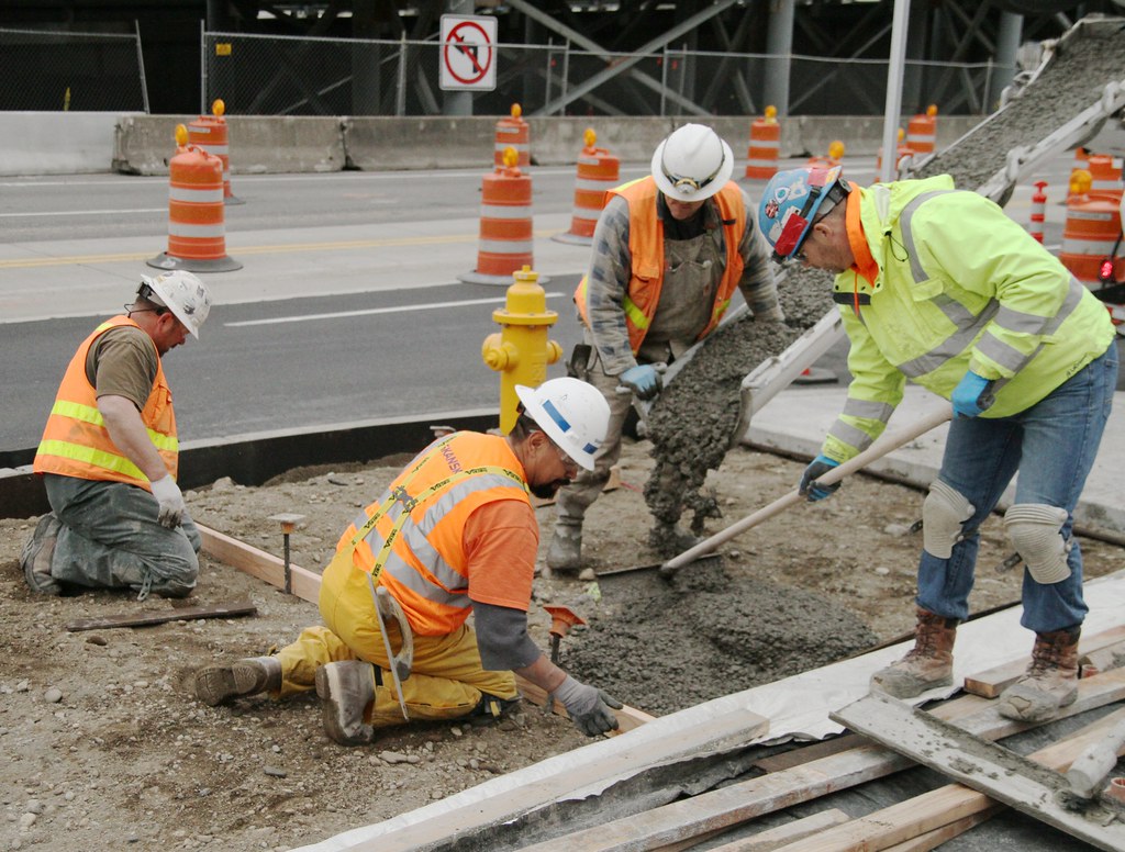Inland Empire infrastructure crew pouring concrete in high-visibility gear with on-site cold water access