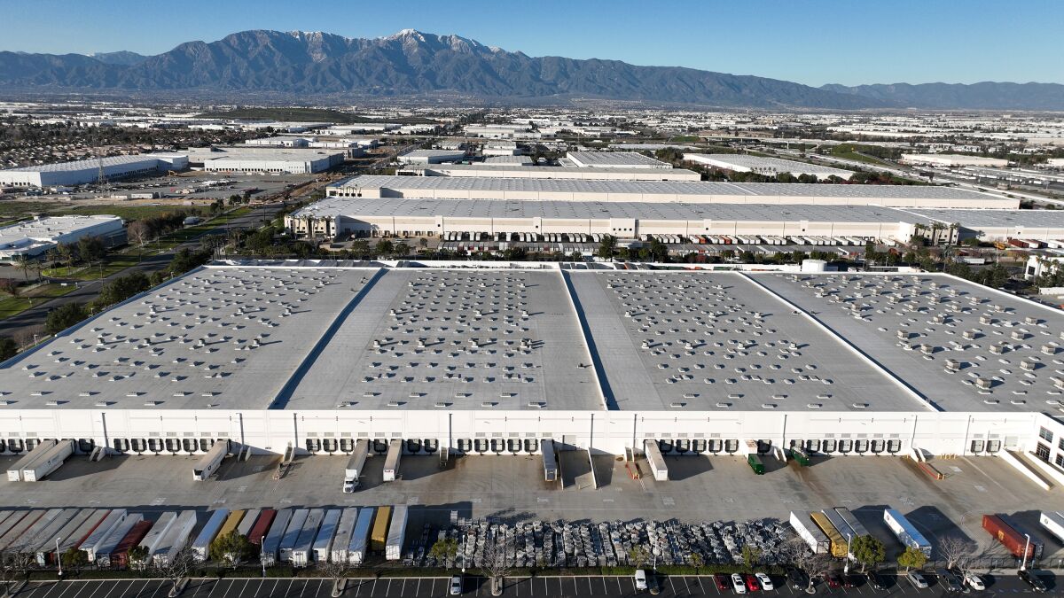 Aerial view of Inland Empire distribution warehouses with the snow-capped San Bernardino mountains behind