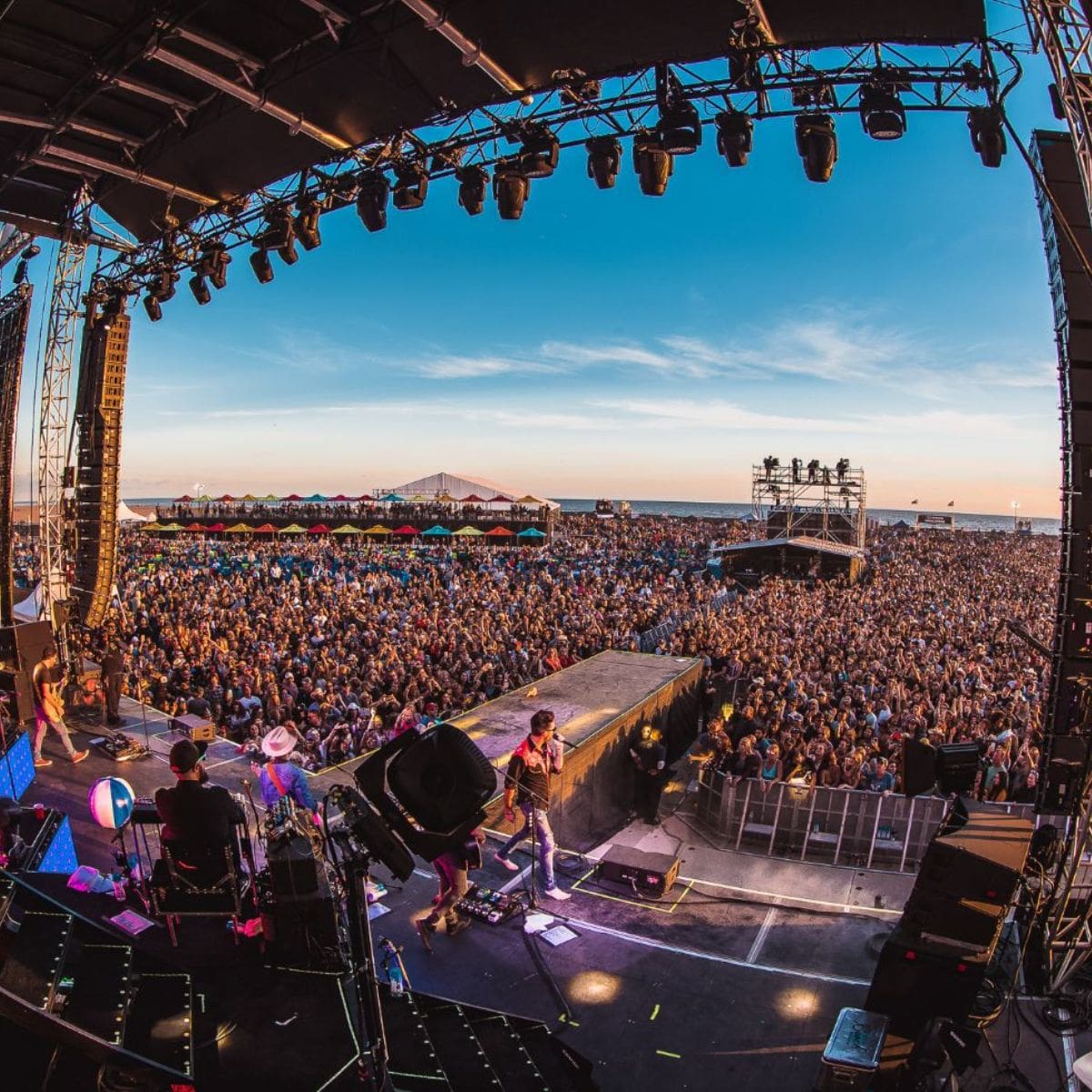 Large outdoor festival crowd under a sunny sky at a Southern California event served by mobile hydration stations