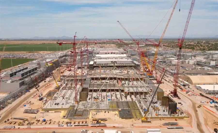 Large desert semiconductor fab construction site near Chandler with cranes served by a mobile drinking water station