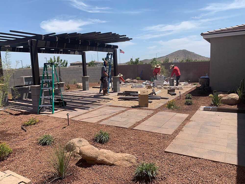 Outdoor landscaping and grounds crew working through Chandler desert heat near a residential development