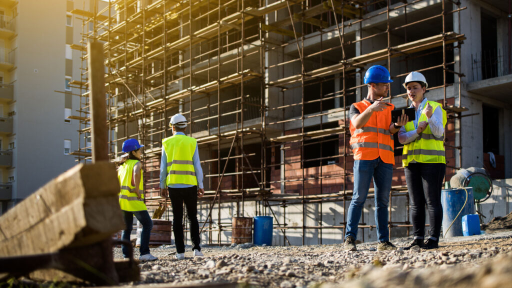 Dallas–Fort Worth construction crew working a steel-frame jobsite in summer heat with on-site water access