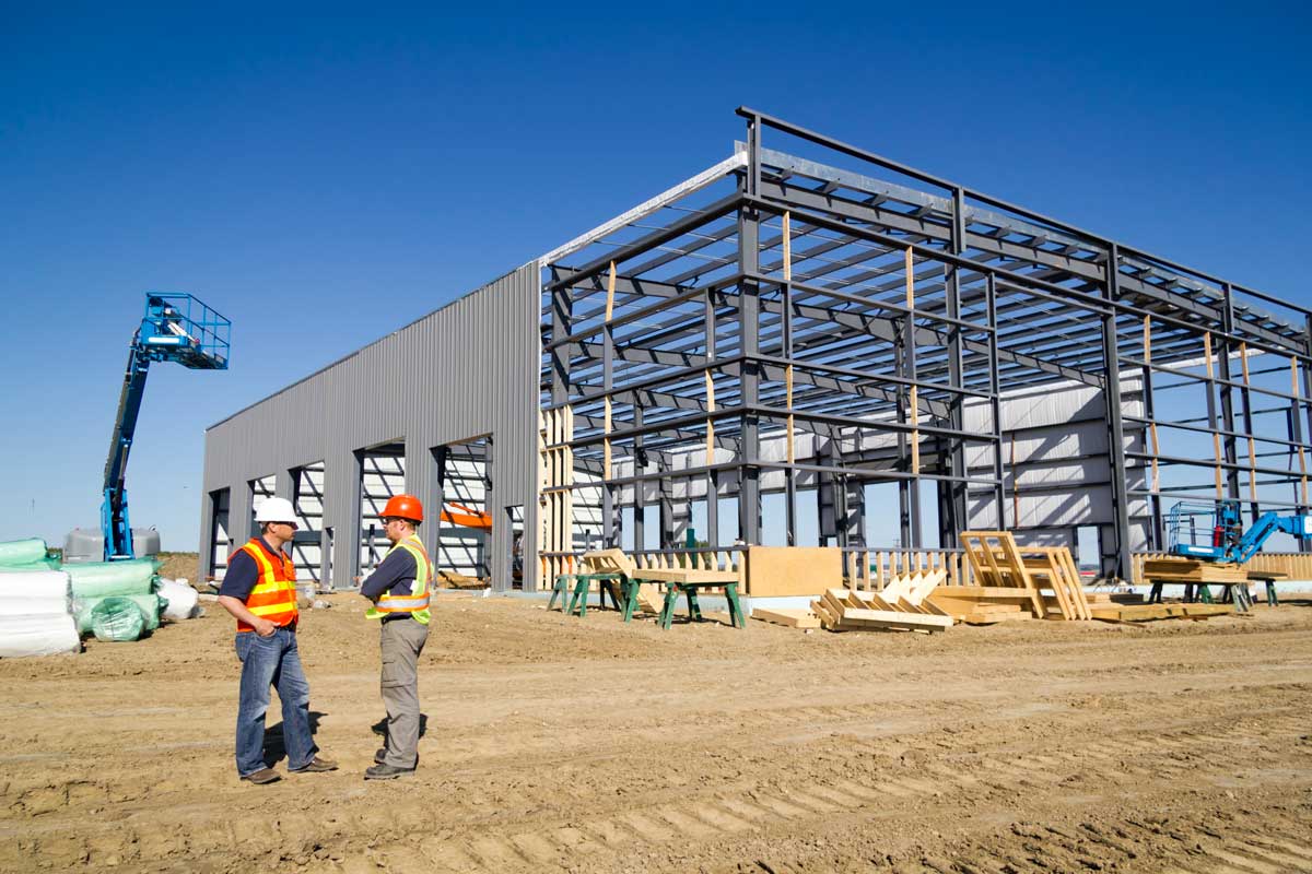 Industrial construction yard with workers under a steel frame in North Texas served by a mobile drinking water station