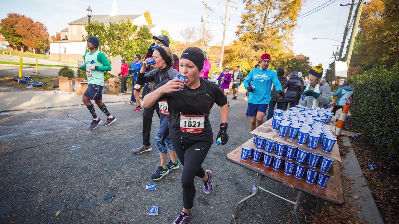Runners refilling at an outdoor water station during a North Texas race event