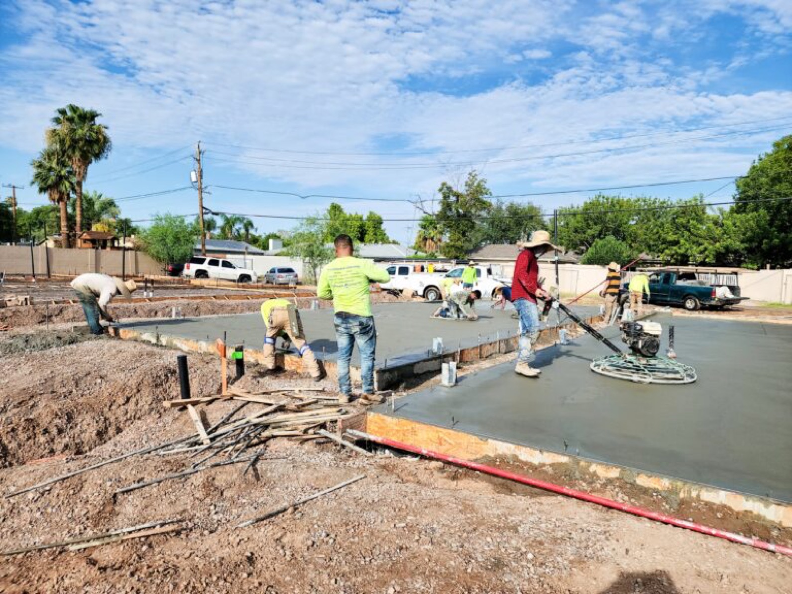 Gilbert construction crew on a concrete pour in bright sun with a mobile water station staged on site