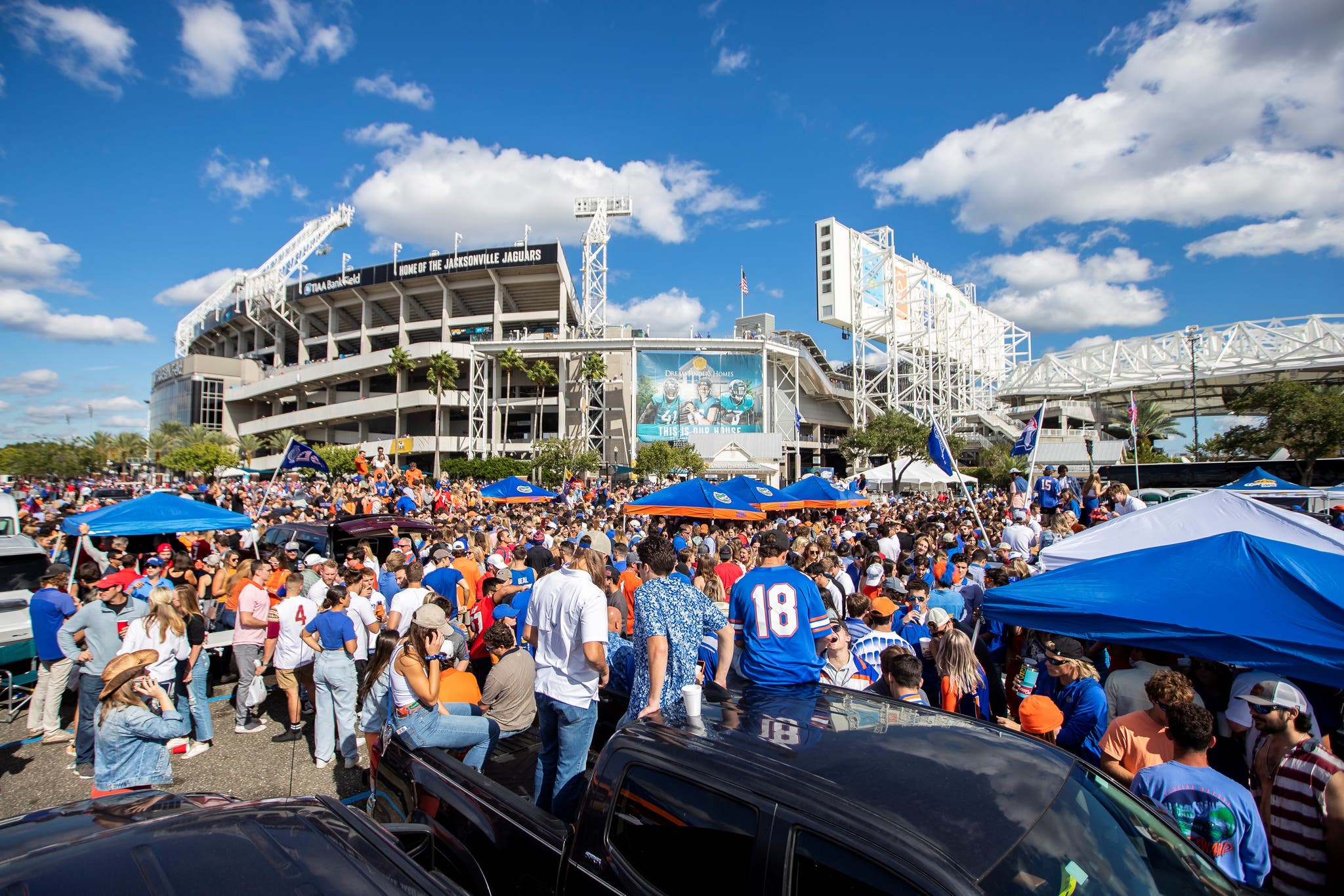 Outdoor stadium crowd tailgating in the sun near State Farm Stadium in Glendale Arizona served by a mobile water station