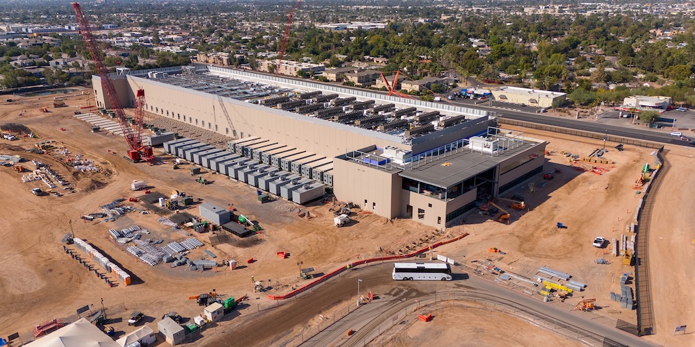 Large desert data center construction site near Phoenix served by a mobile drinking water station