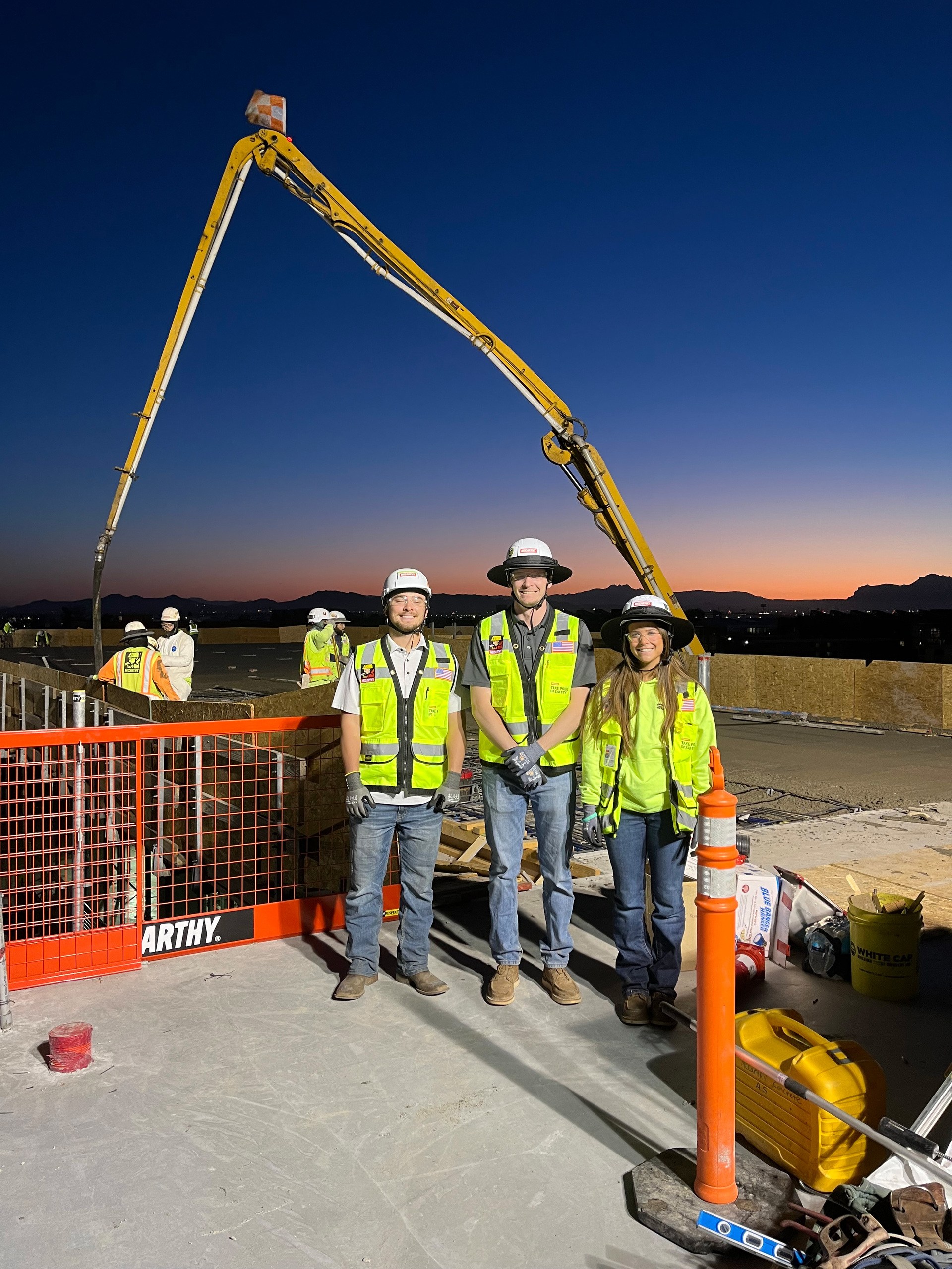 Phoenix construction crew on a concrete pour at dusk with a mobile water station on site