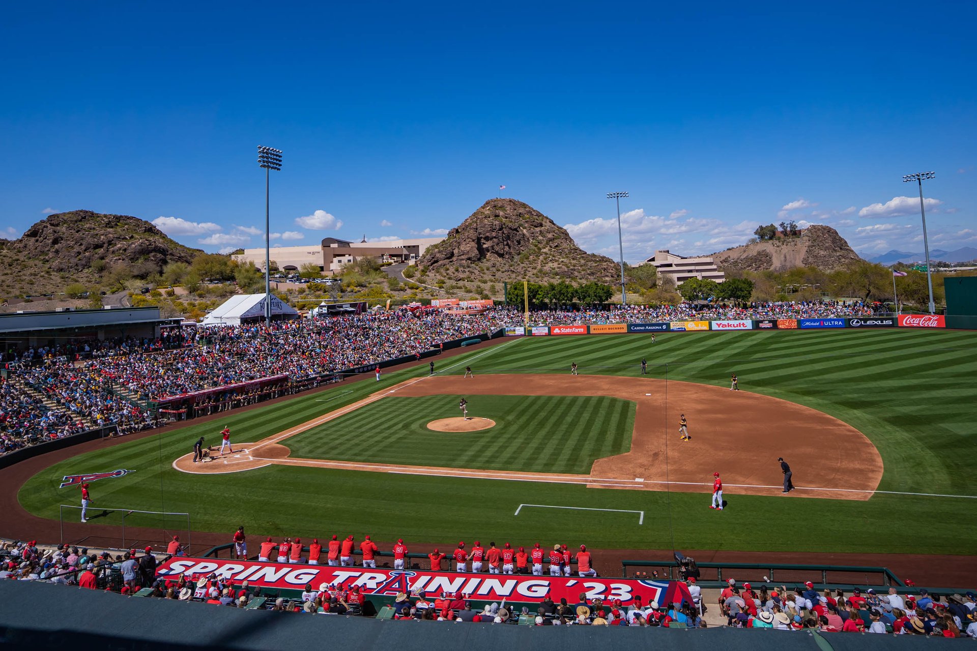 Spring training ballpark with desert buttes behind the outfield, representing Cactus League crowds served by Scottsdale hydration stations