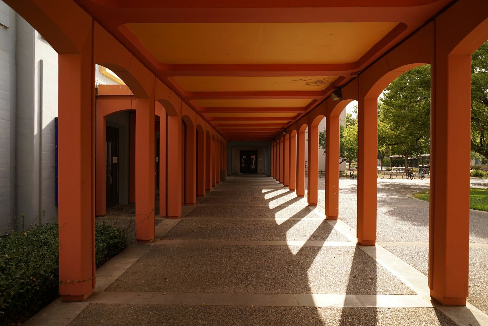 An orange-painted covered walkway between university buildings