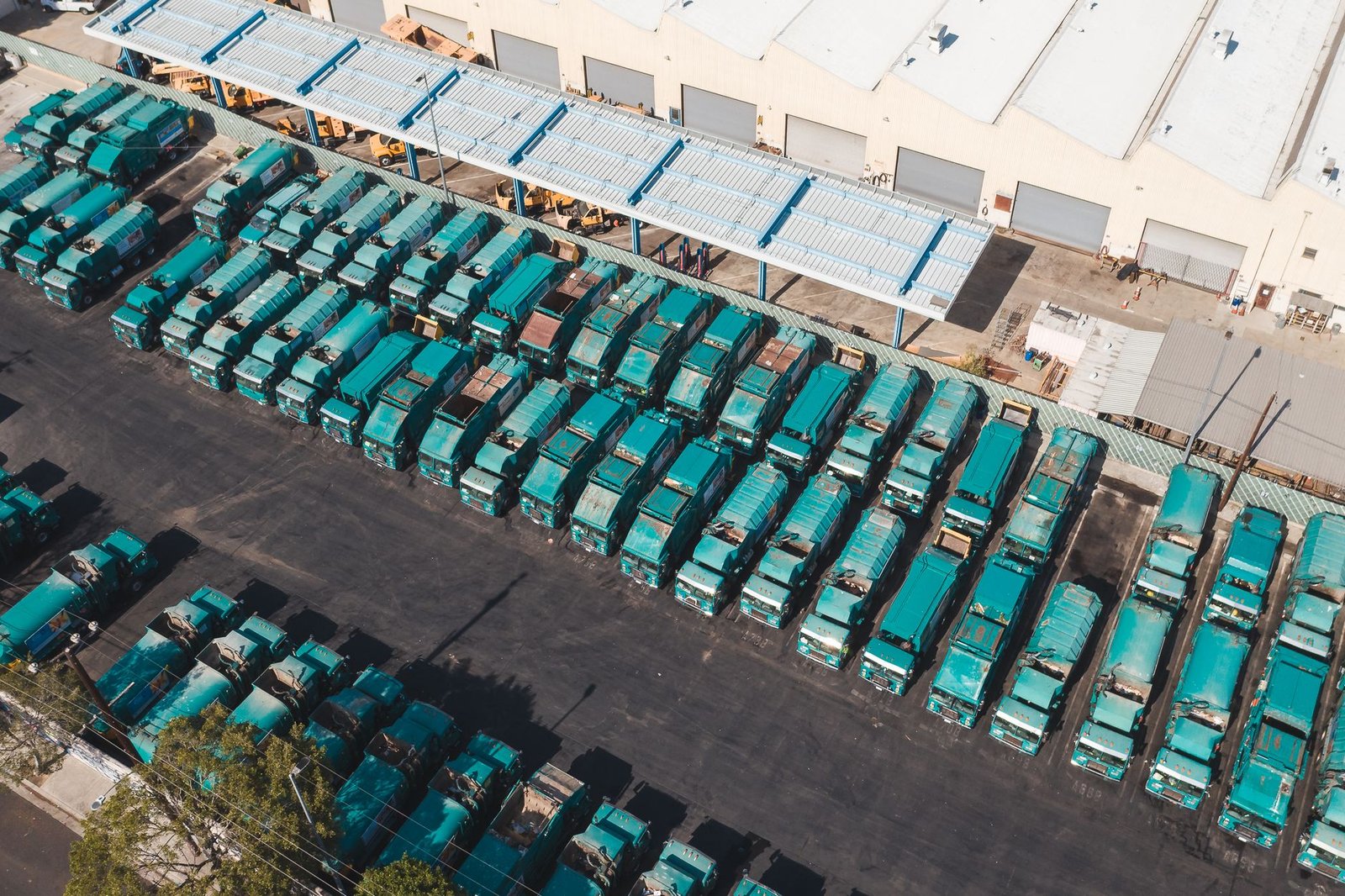 An aerial view of a fleet yard with rows of trucks parked beside a warehouse