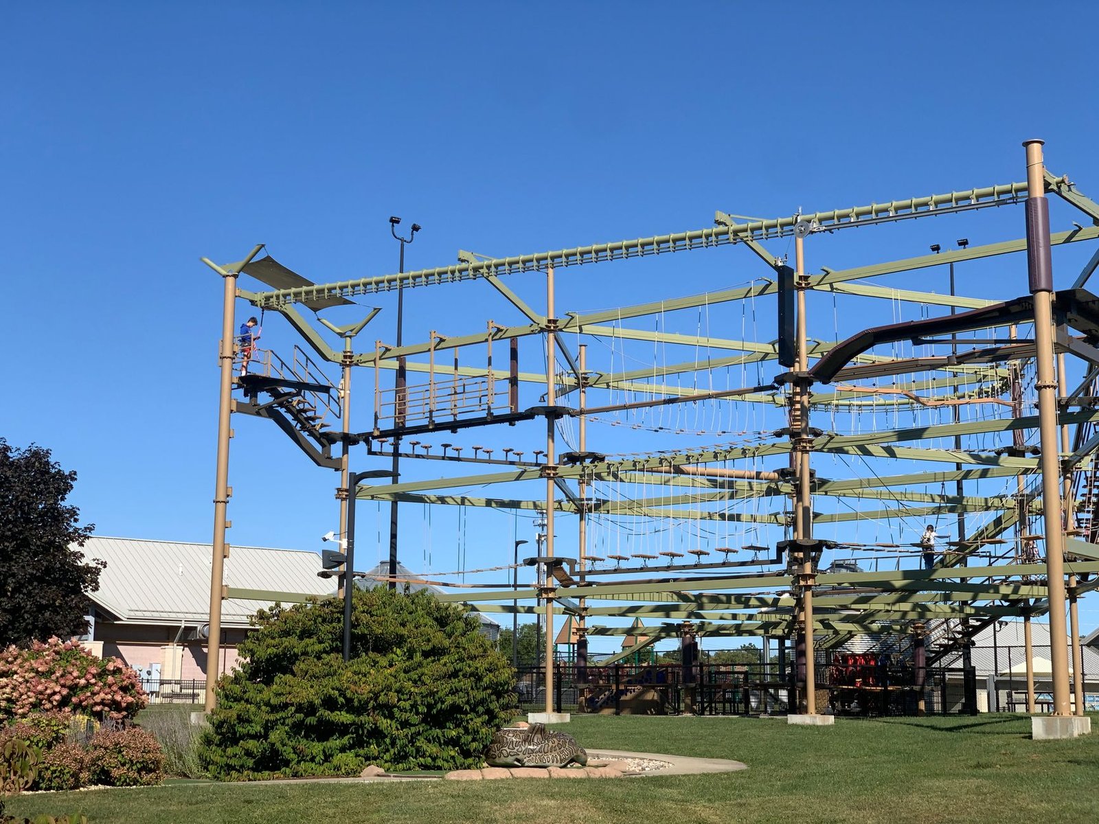 An outdoor ropes and climbing course beside a recreation center building