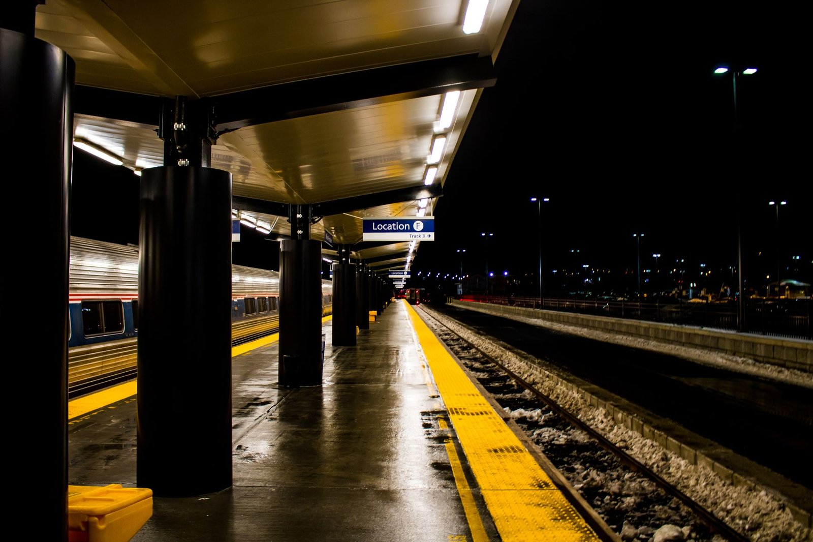A covered commuter rail platform at night