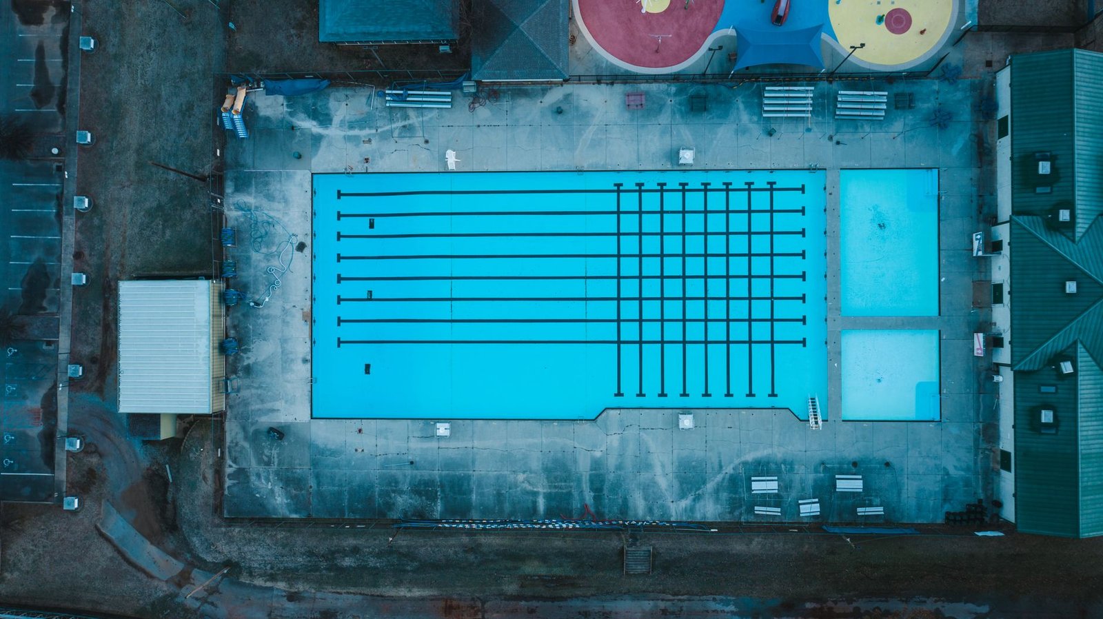 An aerial view of an outdoor recreation-center pool complex with lap lanes