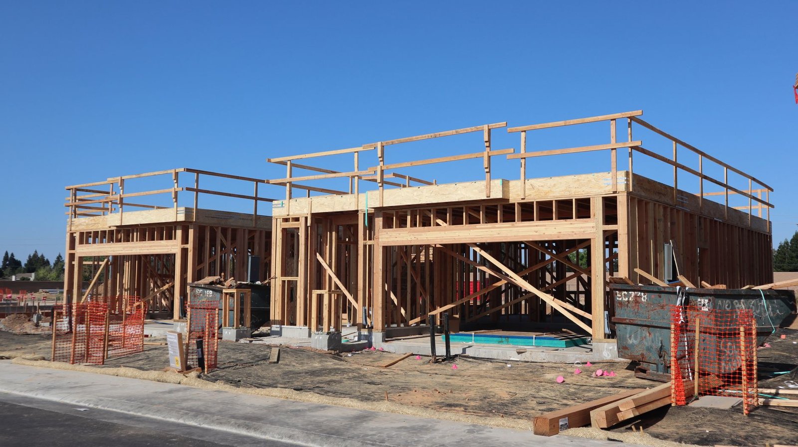 Wood-framed new homes under construction on a residential street